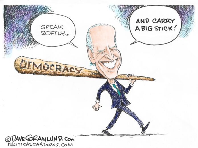 Joe Biden carries a large wooden club inscribed with 